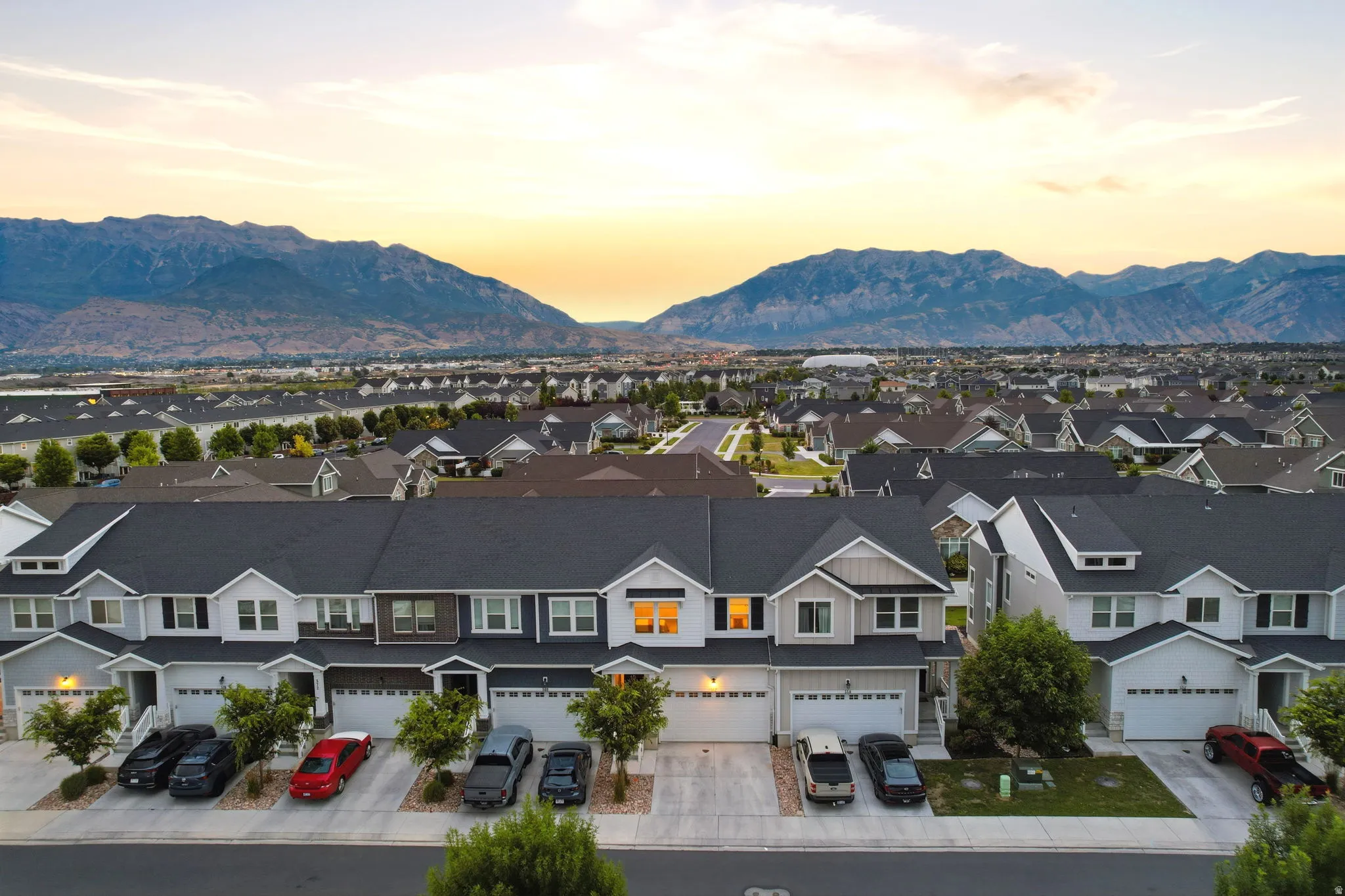 Residential community featuring a variety of housing styles, mountain backdrop, and individual garages