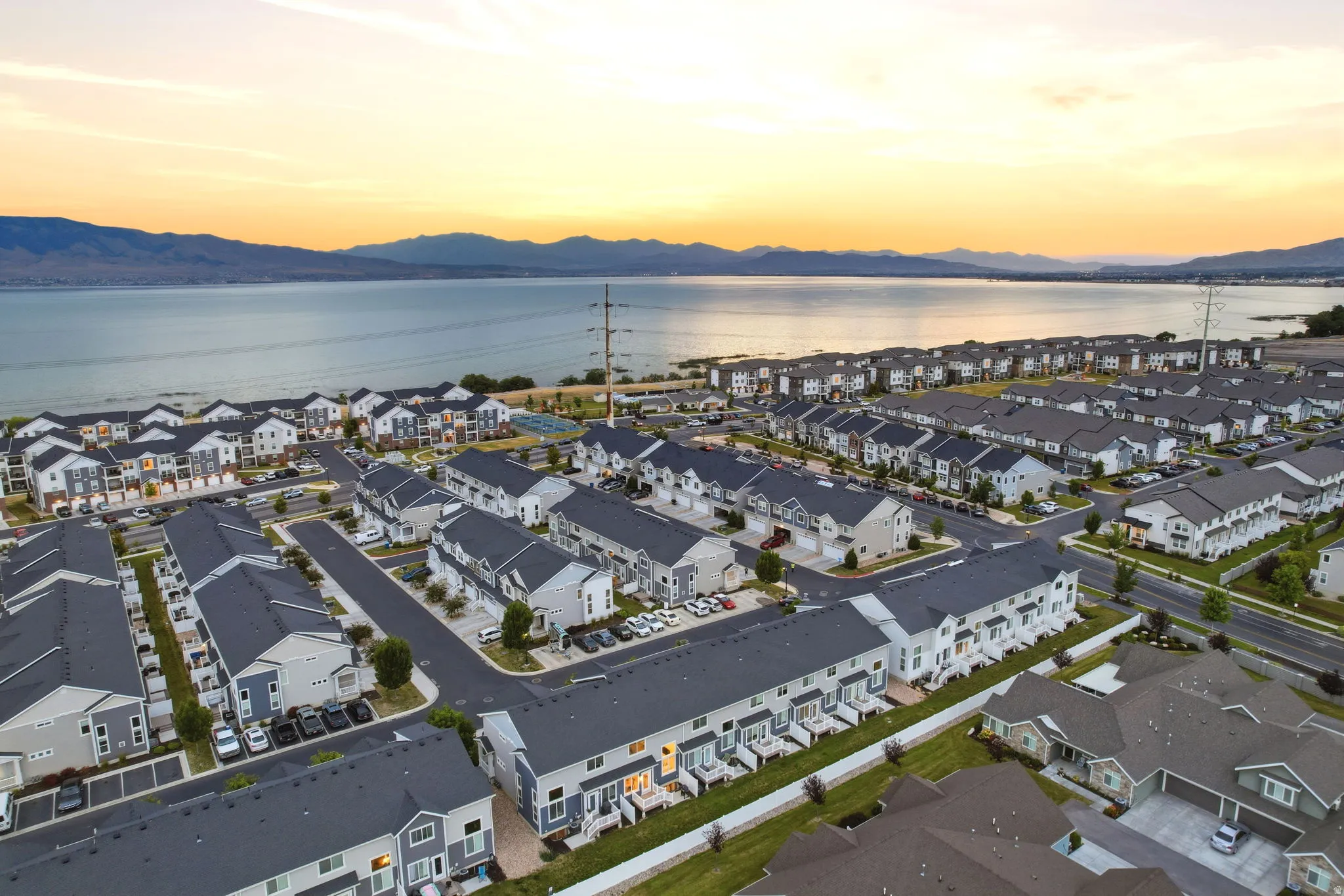Aerial perspective showcasing a residential community with lake and mountain scenery
