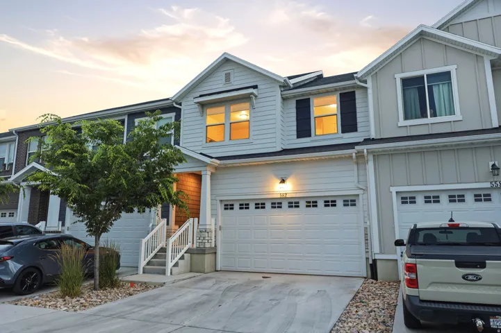 Contemporary multi-level residence featuring light-colored siding and dark window shutters