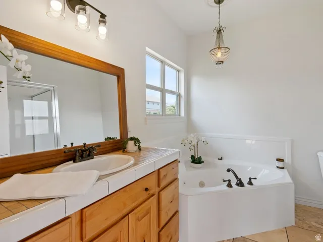 Primary bathroom features corner soaking tub and a separate glass shower enclosure