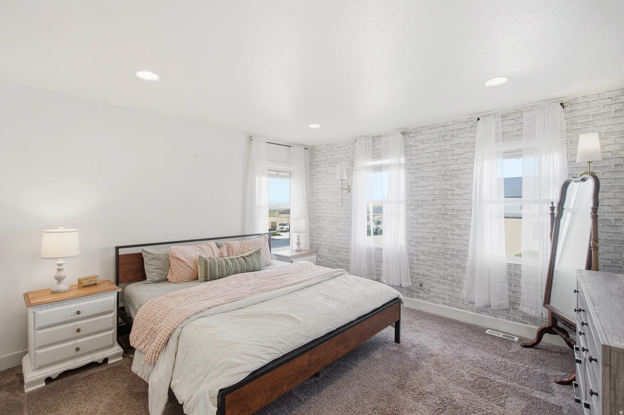 Bedroom featuring a textured accent wall with a whitewashed brick finish