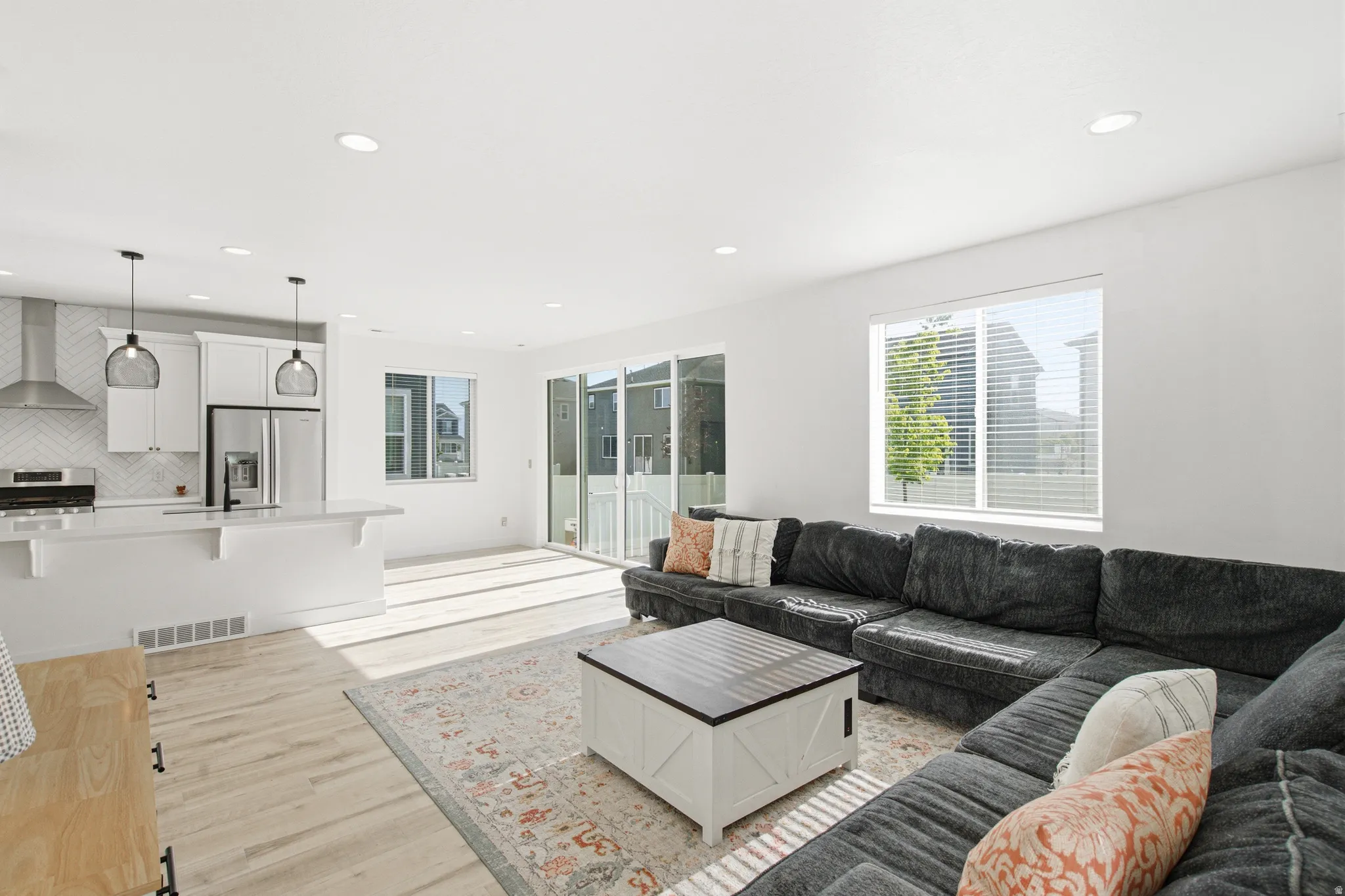 Open-concept living space featuring wood-finish flooring, recessed lighting, and white walls