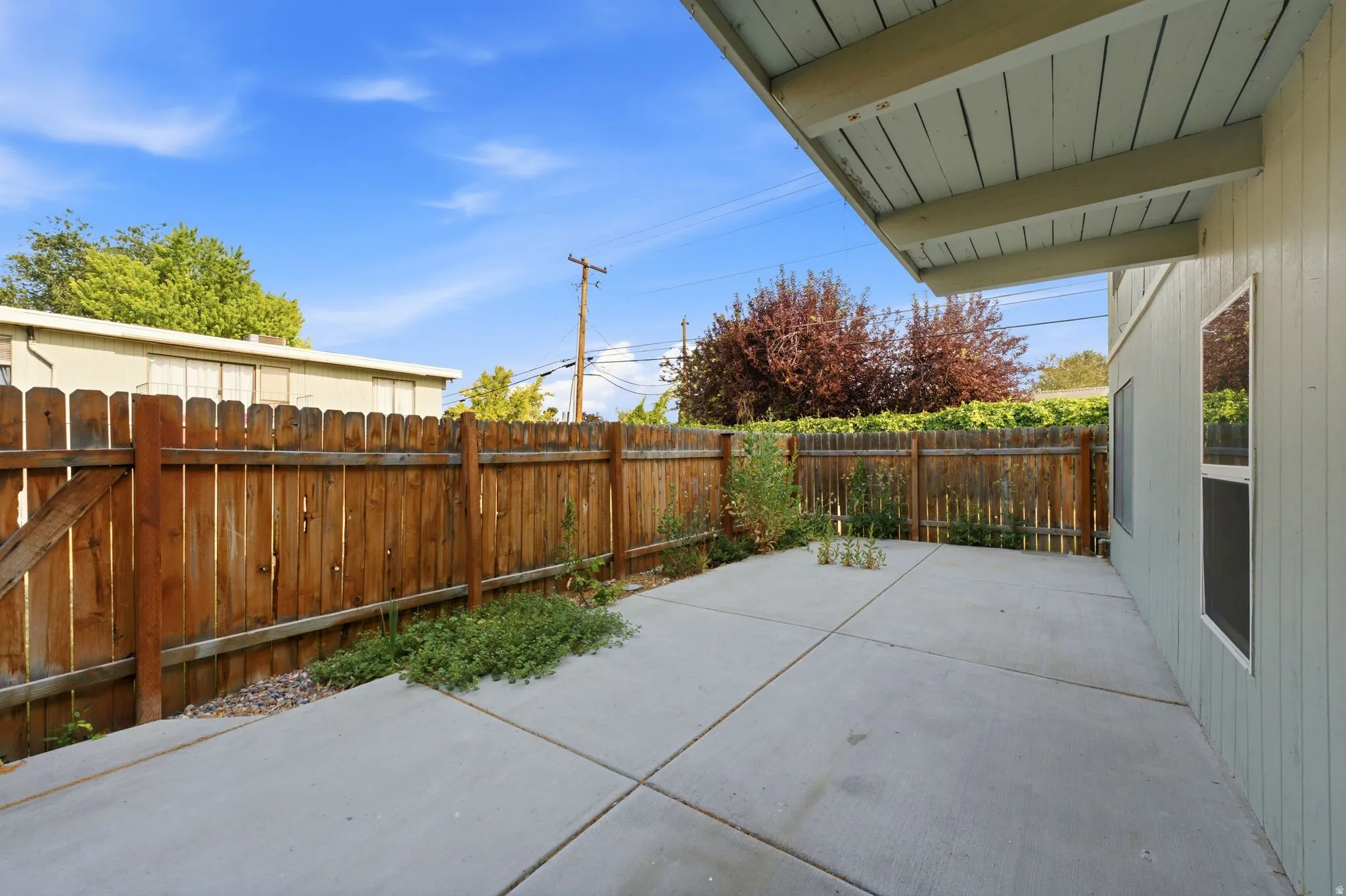 Expansive concrete patio with a full privacy fence