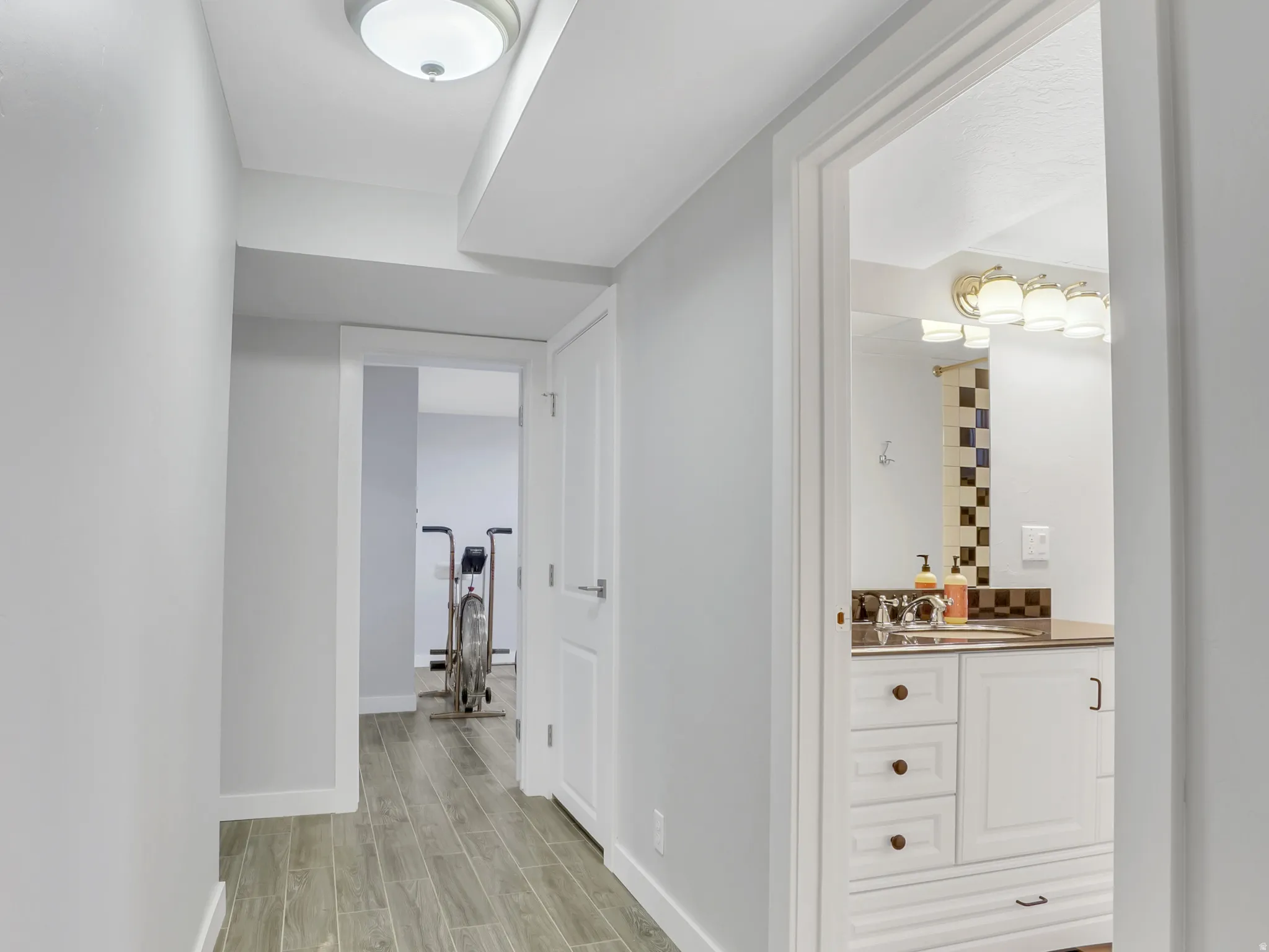 Hallway featuring wood-finish tile flooring and recessed overhead lighting