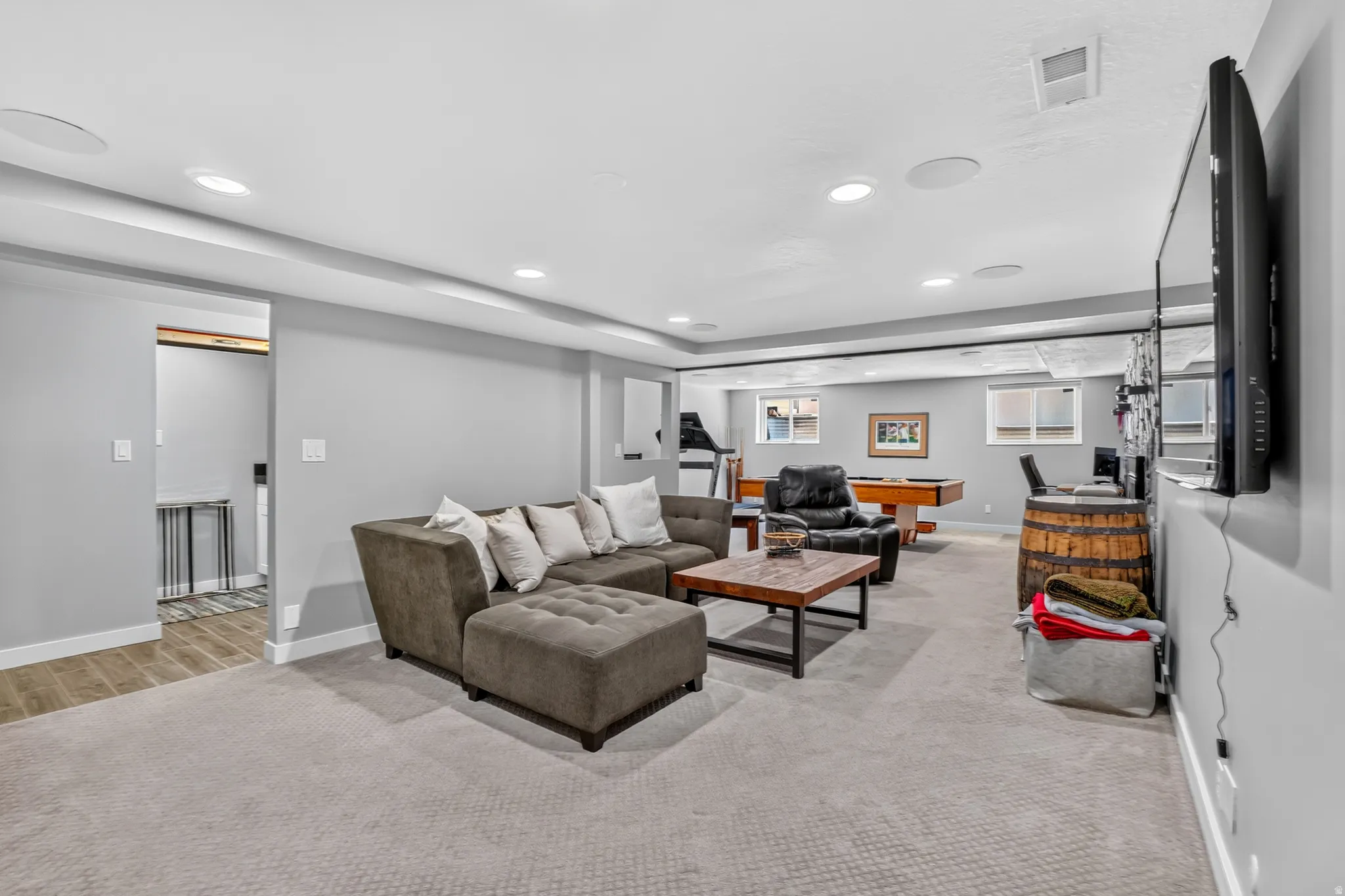 Spacious recreational area featuring recessed lighting, light gray carpeting, and painted gray walls