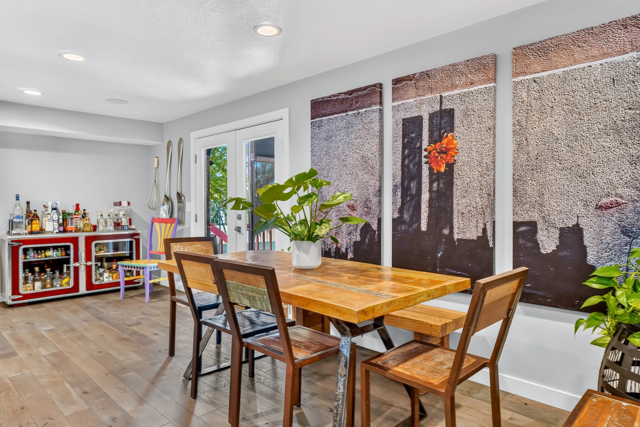 Dining area featuring wood-finish flooring, recessed lighting, and a prominent art installation