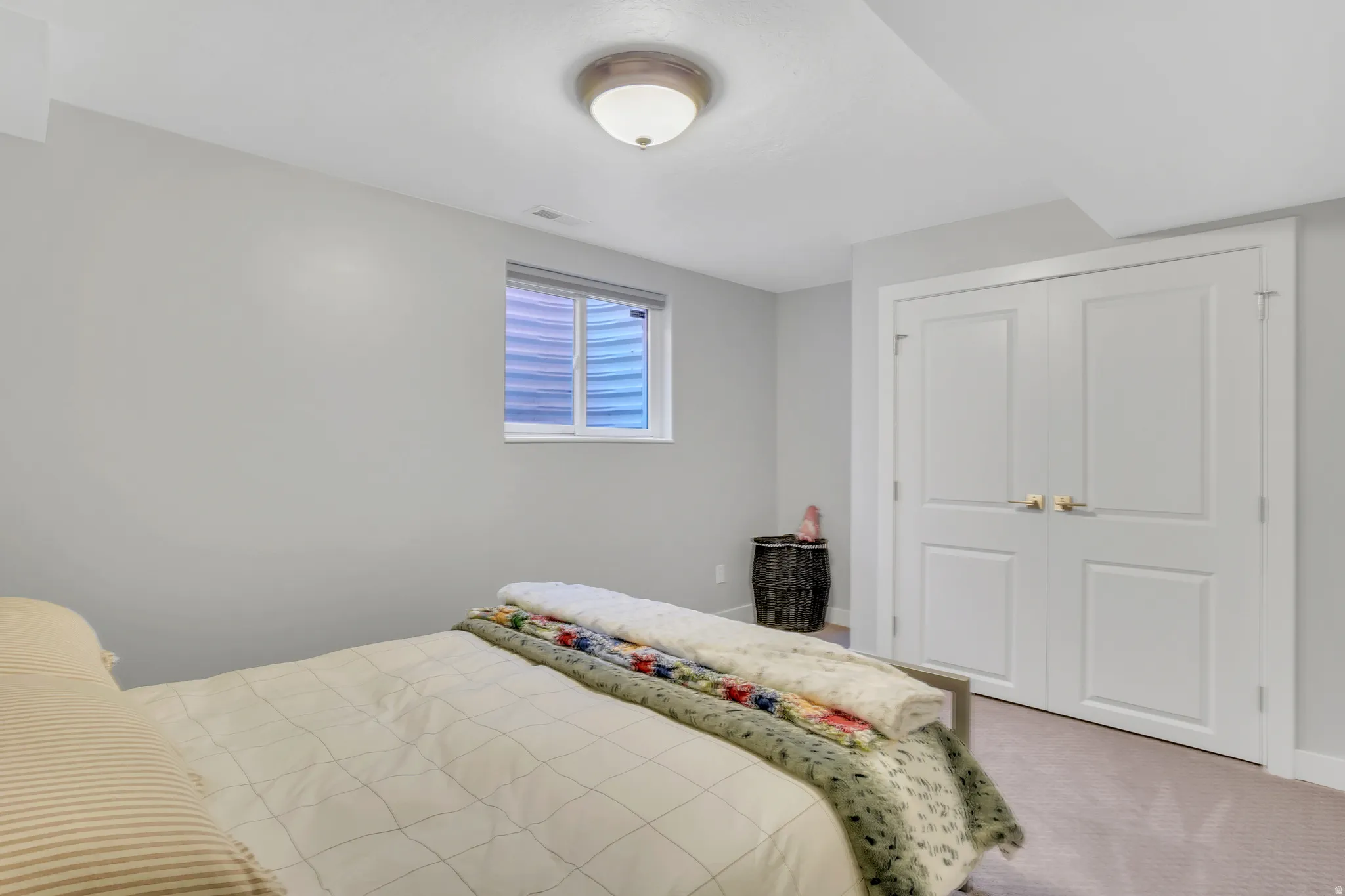 Neutral-toned bedroom featuring carpeted flooring and a flush-mount ceiling light fixture