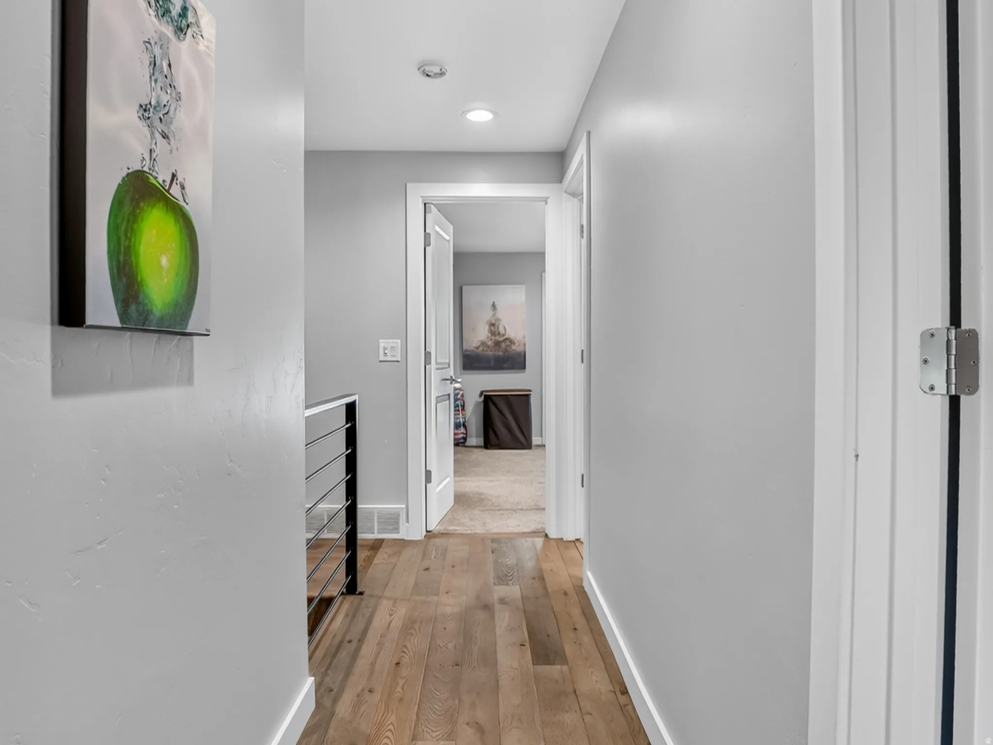 Hallway featuring light wood-finish flooring, recessed lighting, and crisp white trim