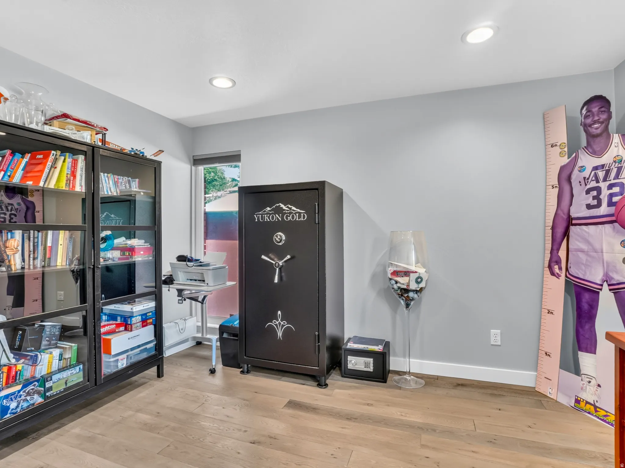 Room with light wood-finish flooring, light gray walls, and recessed lighting