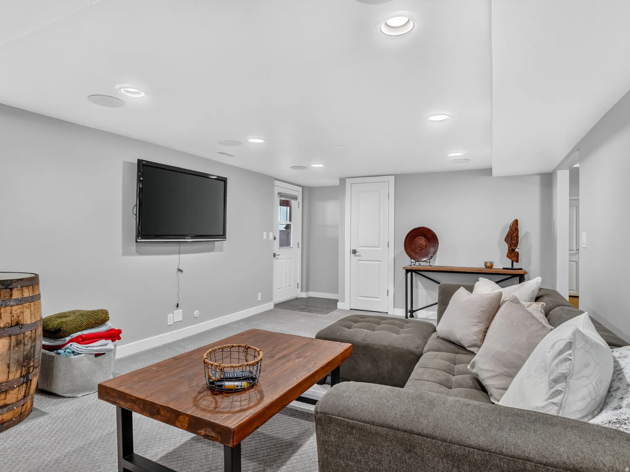 Lower-level living area with recessed lighting, light gray wall paint, and gray carpet flooring