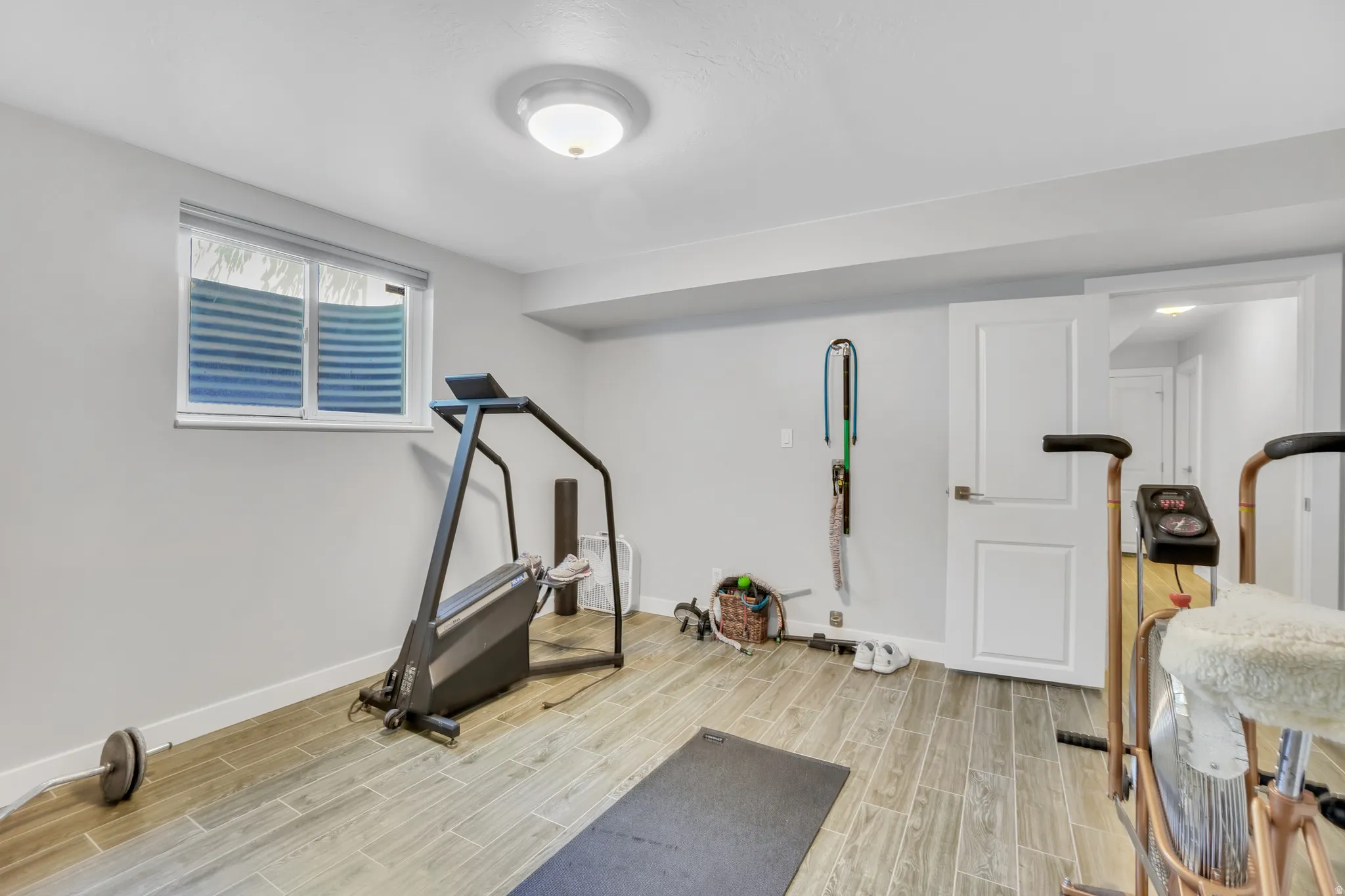 Lower level room featuring wood-finish flooring, light grey wall paint, and recessed lighting