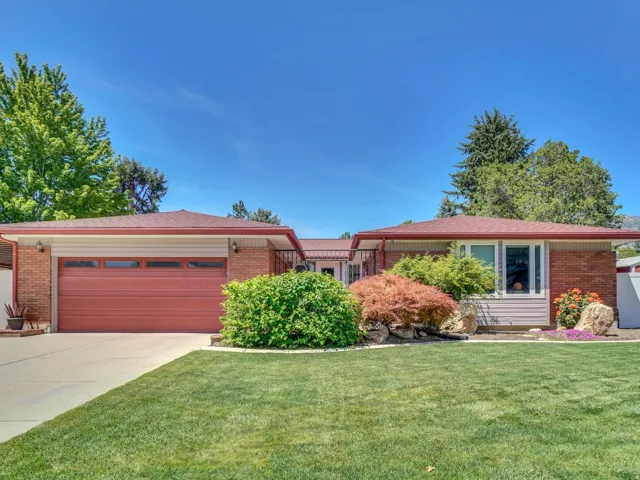 Brick and siding exterior with a red garage door and complementary red shingle roof