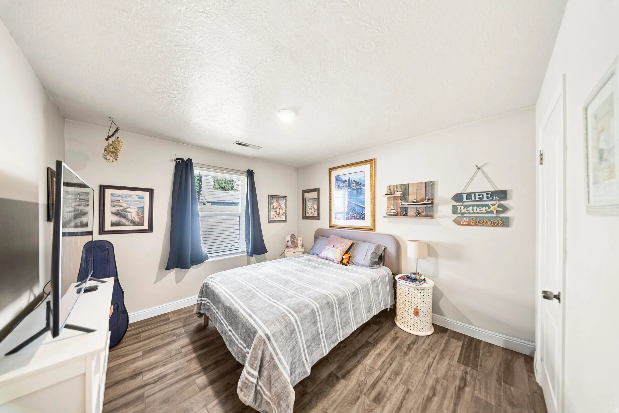 Spacious bedroom featuring wood-finish flooring and neutral wall tones