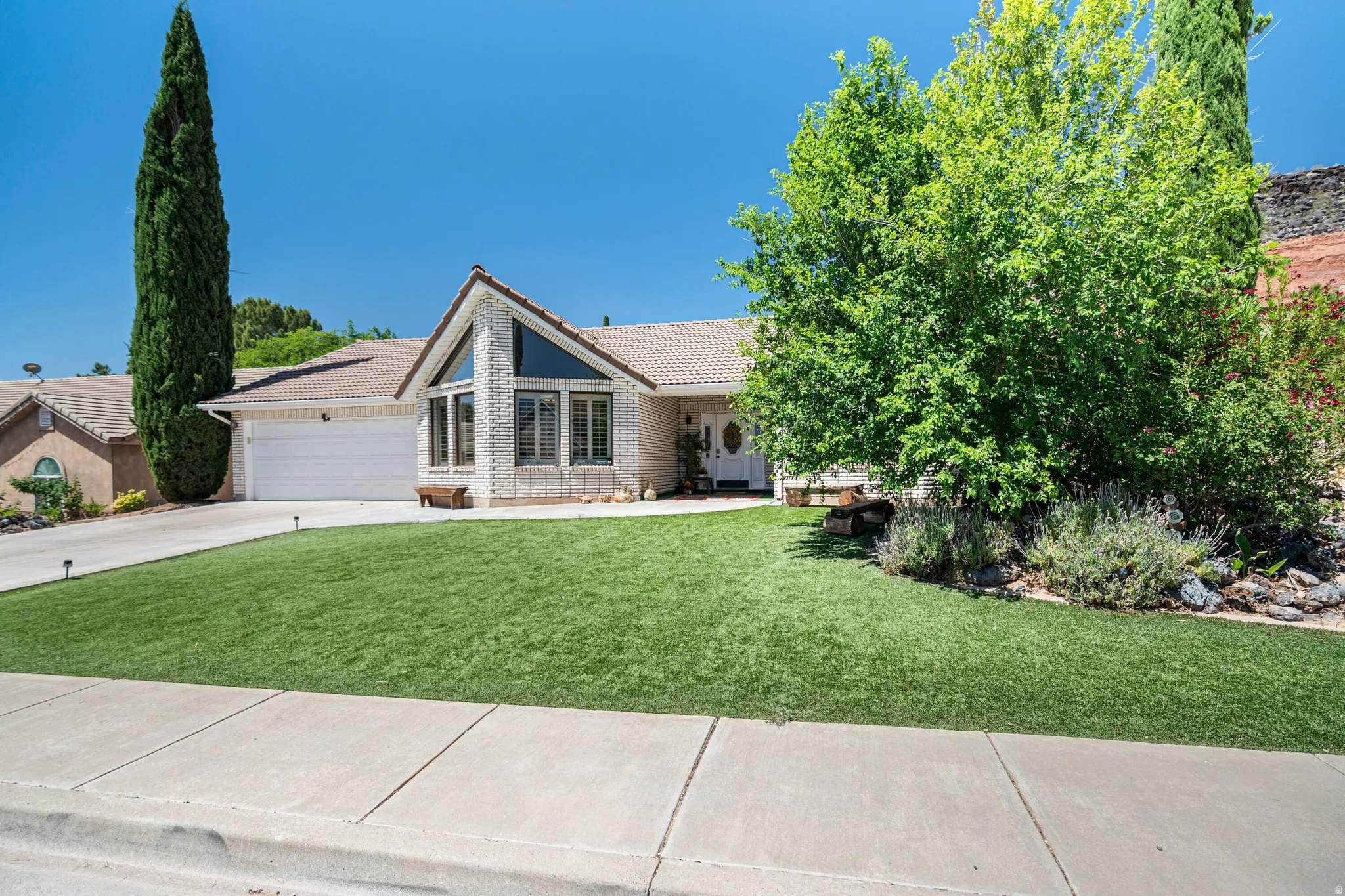 Exterior facade featuring a two-car garage, pitched tile roof, and a prominent front entrance
