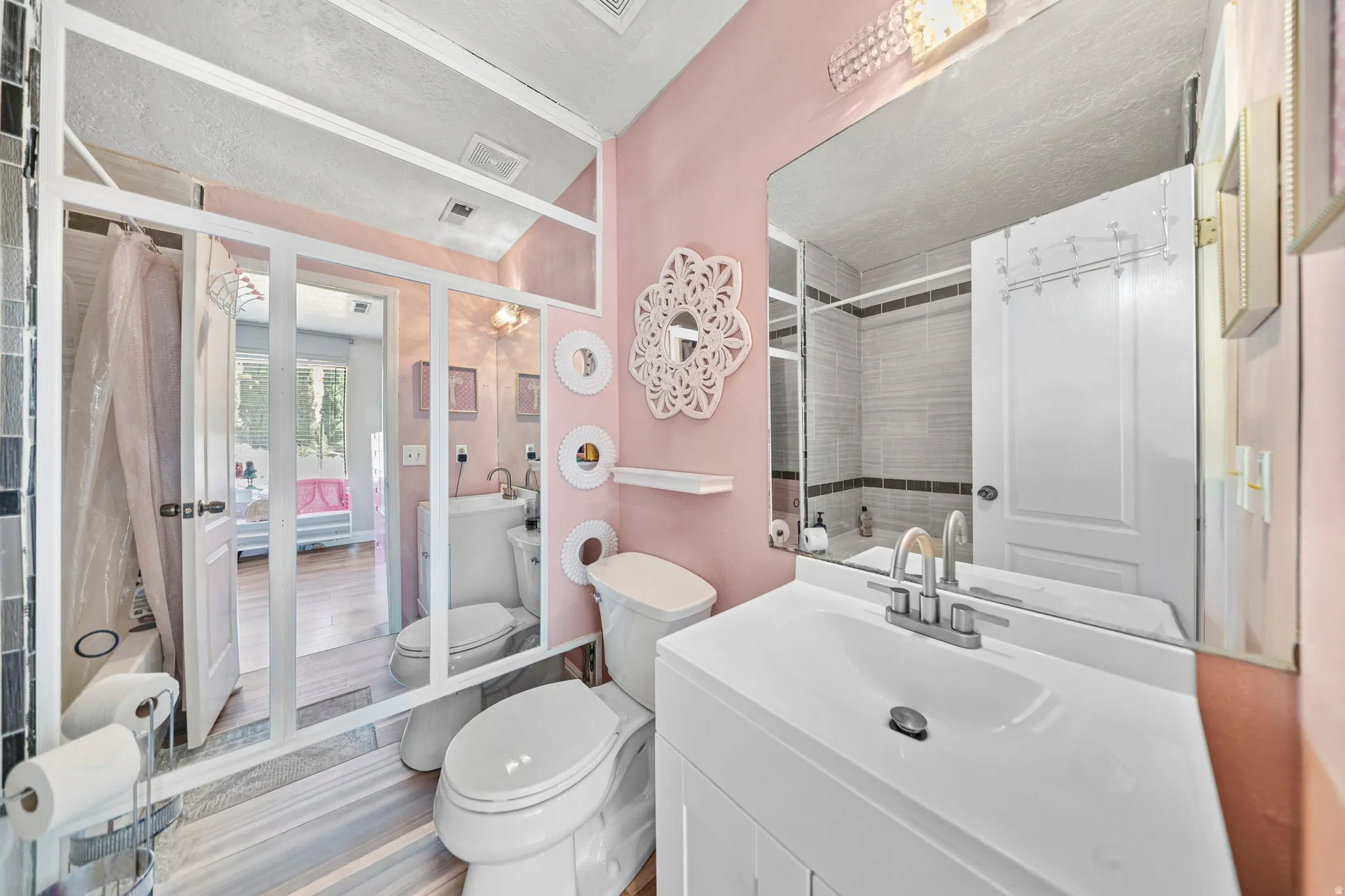 Bathroom featuring a single vanity with an integrated sink, polished chrome faucet, and a large wall-mounted mirror