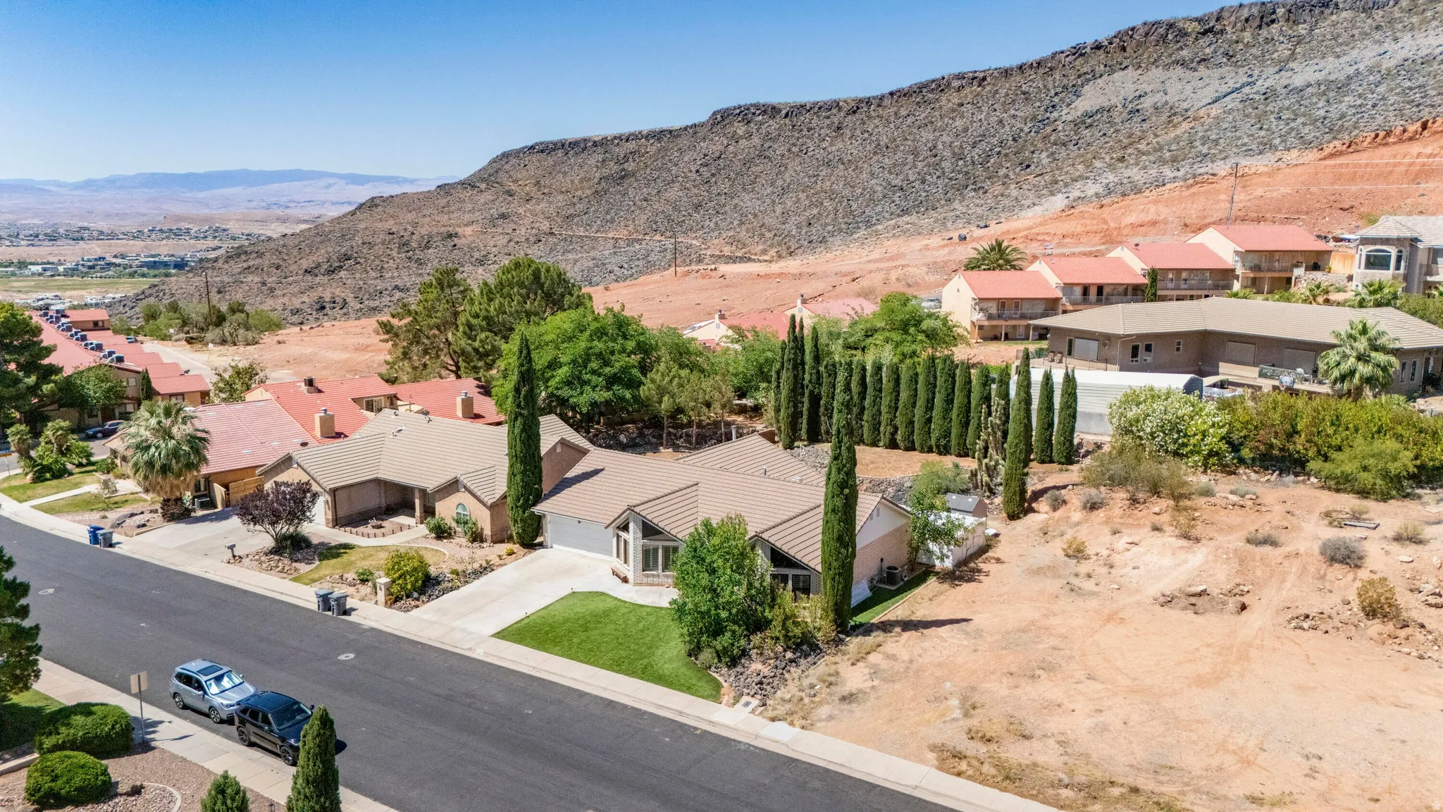 Single-story property with a light-colored stucco exterior and a tan shingle roof