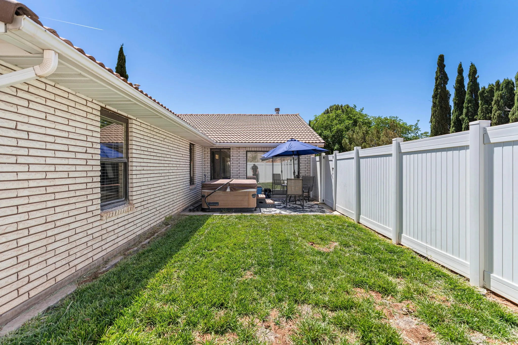 Backyard featuring a paver patio with a built-in spa, framed by a full privacy fence