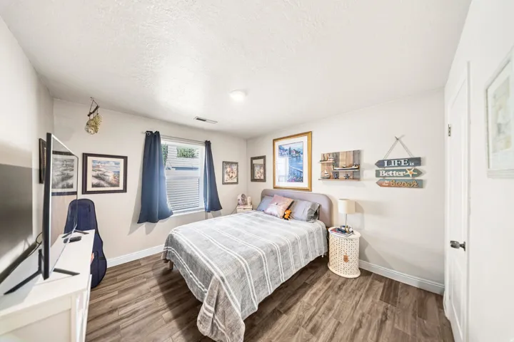 Spacious bedroom featuring wood-finish flooring and neutral wall tones