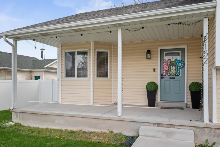 Inviting covered porch with concrete flooring and a light-colored exterior facade