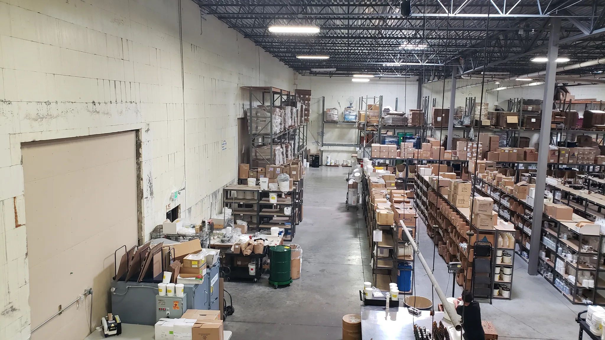 Expansive industrial interior featuring a high exposed truss ceiling and a concrete floor