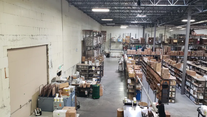 Expansive industrial interior featuring a high exposed truss ceiling and a concrete floor