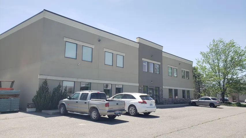 Contemporary commercial building featuring a multi-tone stucco exterior, a stone veneer facade, and expansive windows