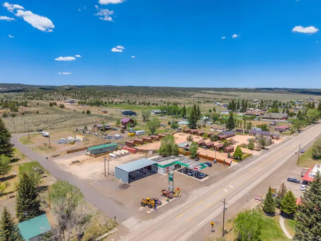Aerial view showcasing a commercial property with a gas station, covered service area, and an adjacent motel complex
