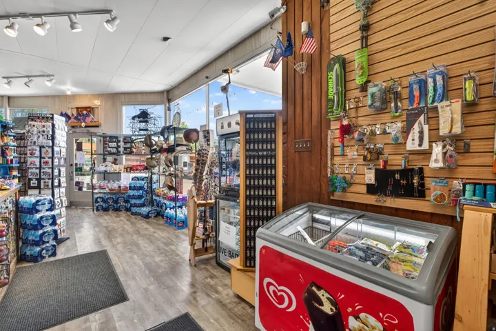 Retail interior featuring wood-finish flooring, drop ceiling with track lighting, and slatwall paneling