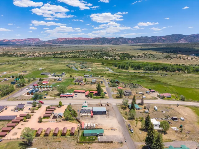 Aerial perspective of a rural settlement against a backdrop of distant red rock formations