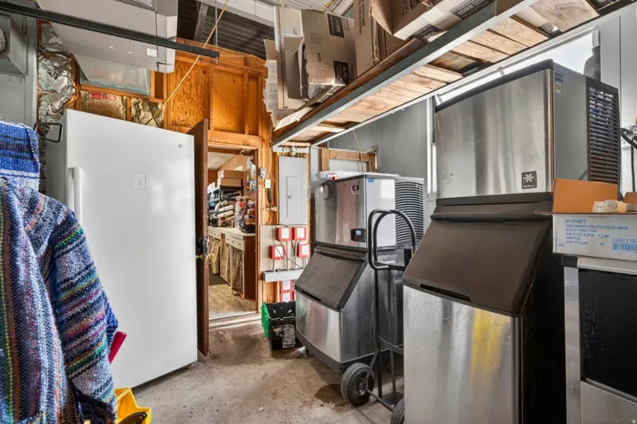 Interior utility area with concrete flooring and multiple stainless steel appliances