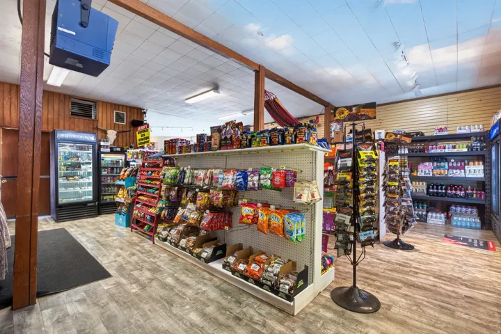 Commercial interior featuring wood-finish flooring, exposed wood beams, and a drop ceiling