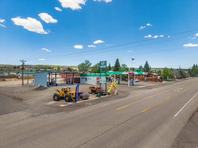 Commercial property featuring multiple structures, extensive paved and unpaved parking areas, and direct road frontage