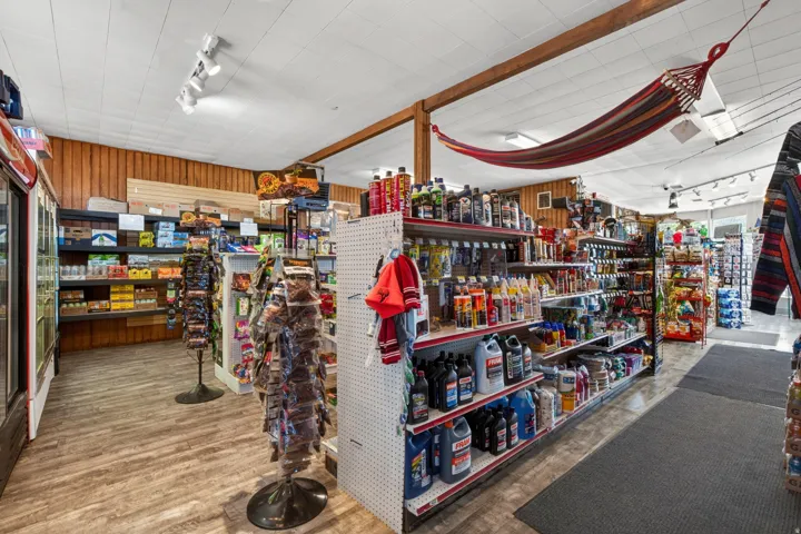 Commercial interior with wood-finish flooring, track lighting, and exposed ceiling beams