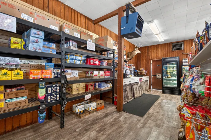 Commercial interior featuring wood-finish flooring, wood-paneled walls, and a dropped ceiling with fluorescent lighting