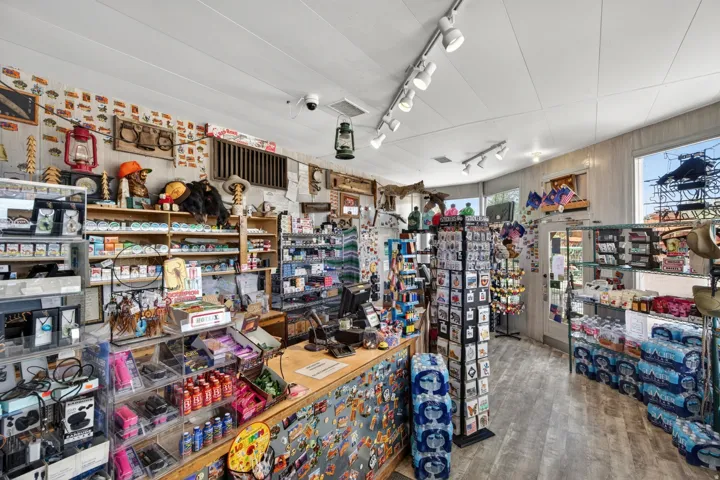 Commercial retail space featuring track lighting, wood-finish flooring, a built-in service counter, and display shelving