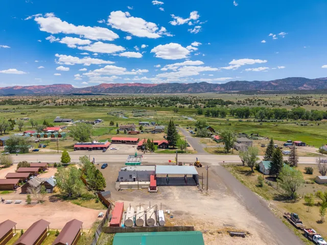 Expansive property with multiple structures, including a commercial building with a covered drive-through area and several smaller cabins