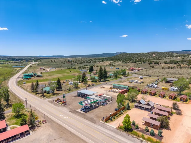 Expansive rural landscape featuring a paved roadway, multiple commercial structures, individual cabins, and surrounding natural terrain