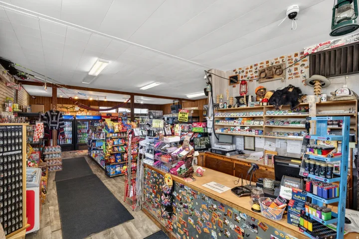 Retail interior featuring wood-finish flooring, fluorescent lighting, and a wood-paneled accent wall