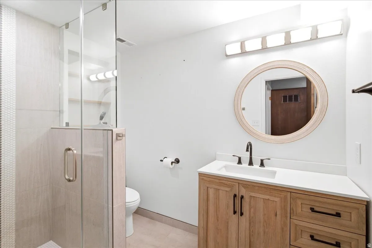 Custom glass-enclosed shower with tile surround and hexagon accent