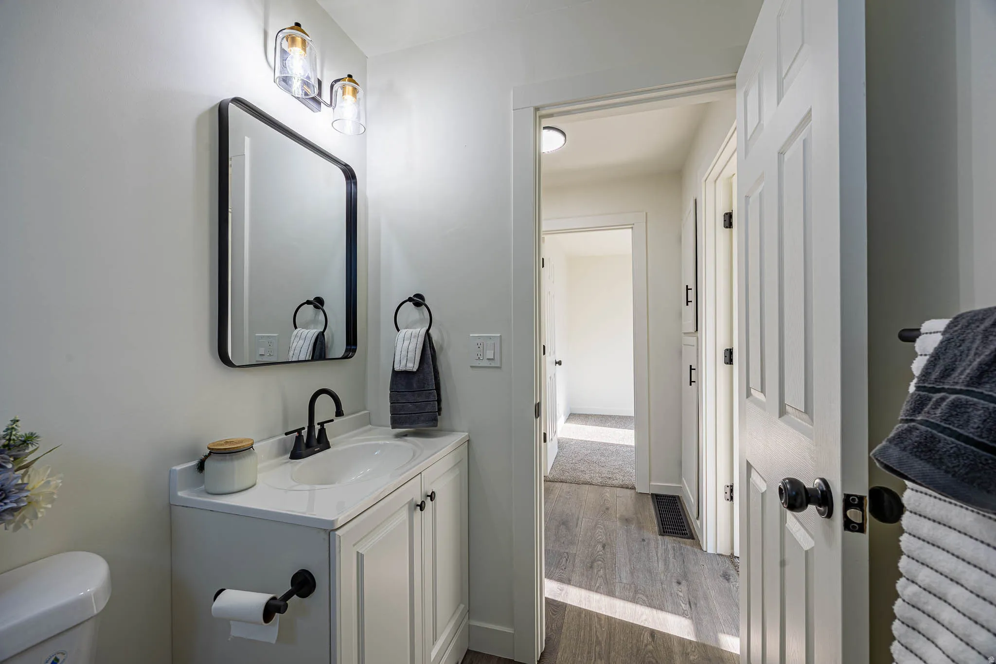 Modern vanity featuring a white countertop, undermount sink, and matte black faucet