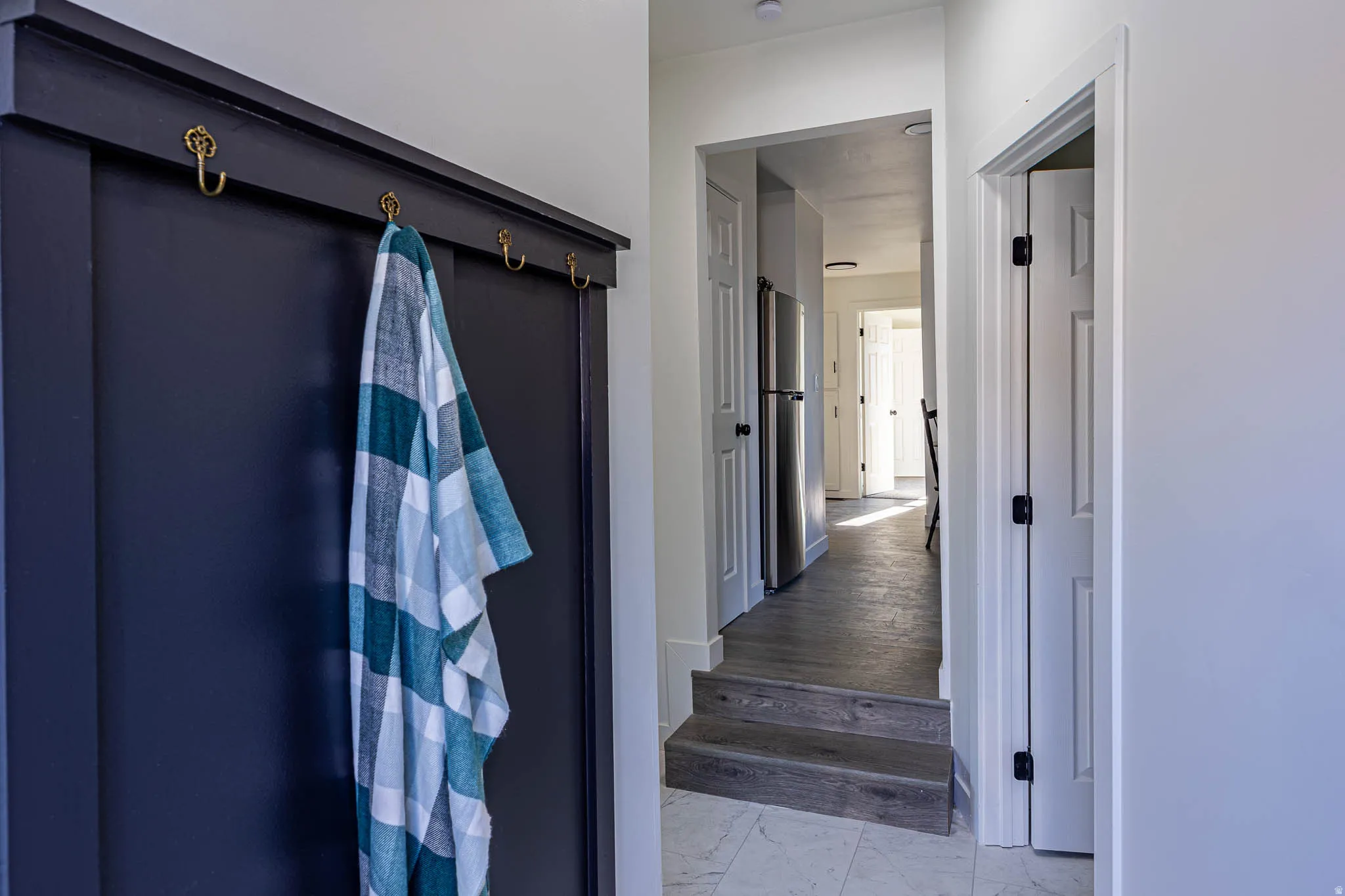 Built-in wall paneling with decorative brass hooks