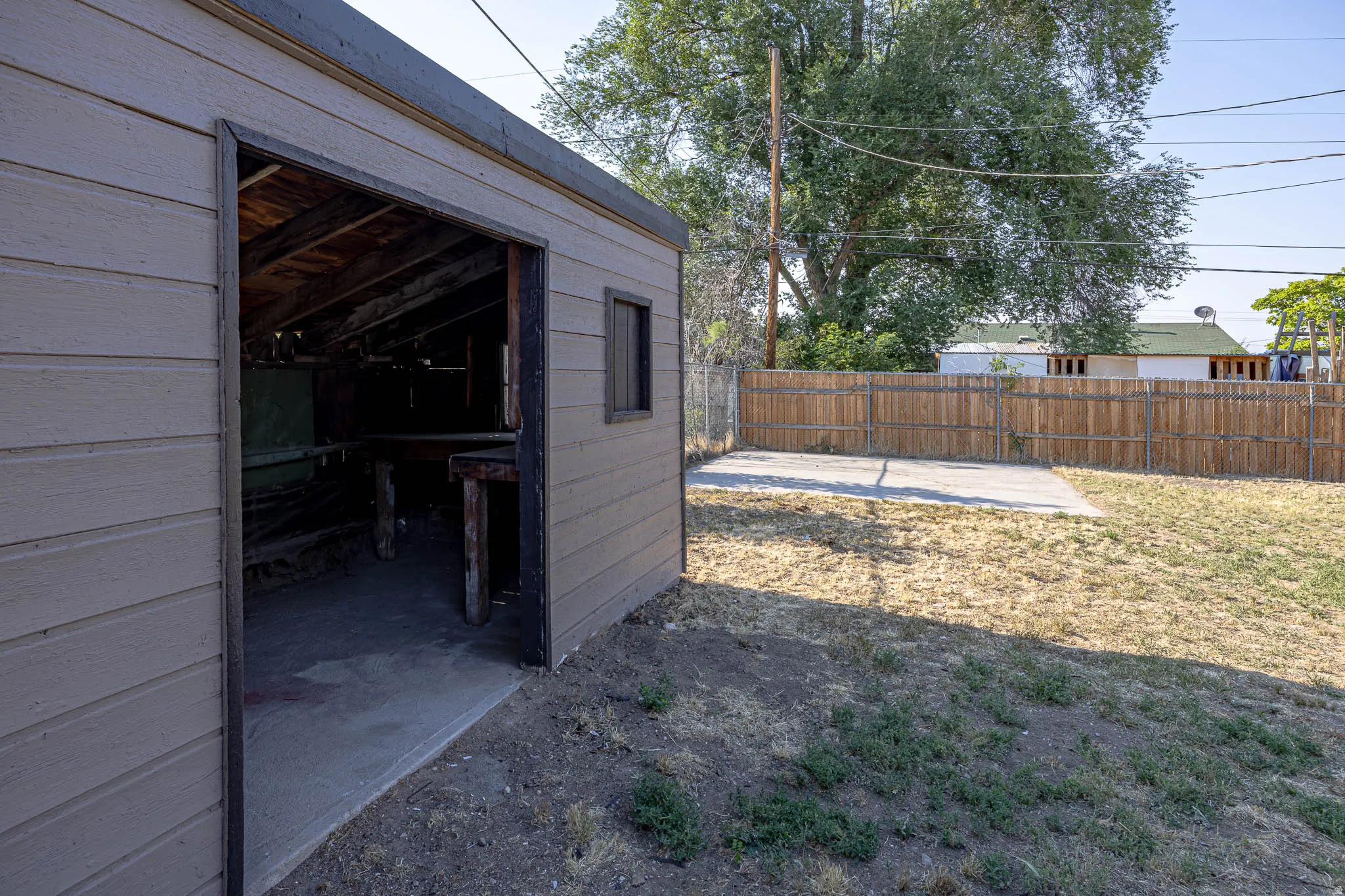 Detached outbuilding with shiplap siding and a concrete floor