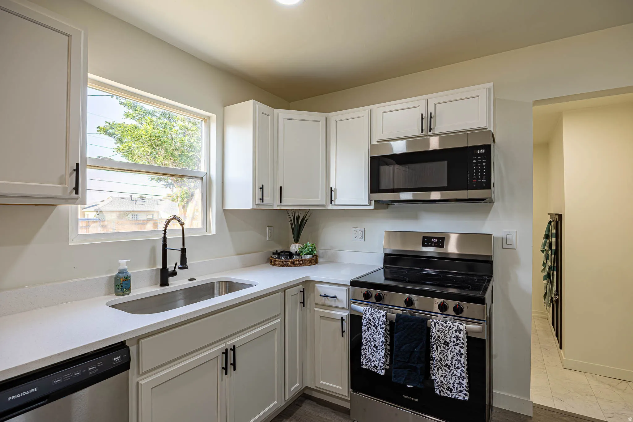 Modern kitchen featuring white shaker cabinetry with matte black hardware