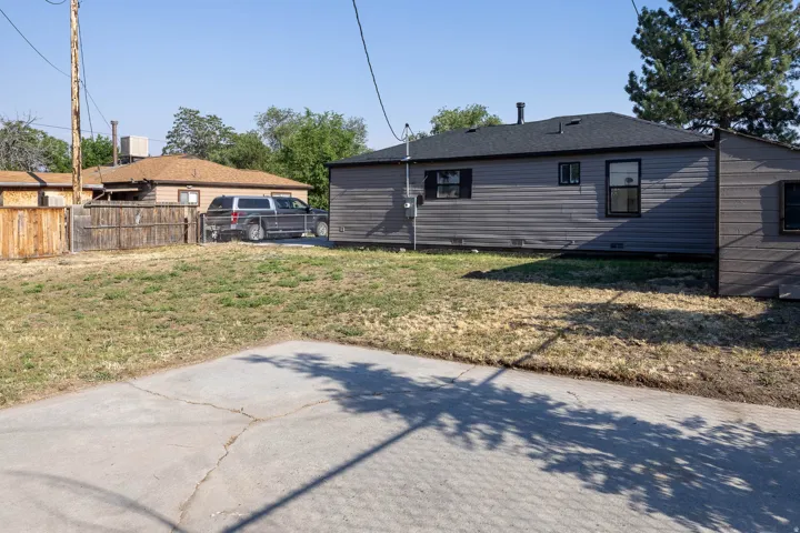 Spacious outdoor area featuring a concrete pad and a partially fenced perimeter