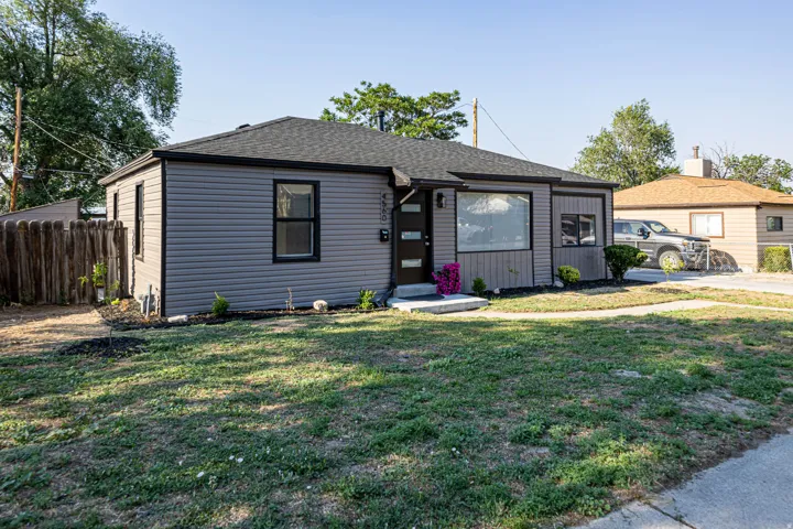 Ranch-style exterior featuring gray horizontal siding and a dark shingle roof
