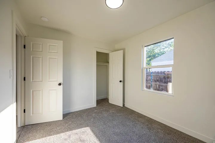 Neutral interior featuring light-colored walls and grey carpet flooring