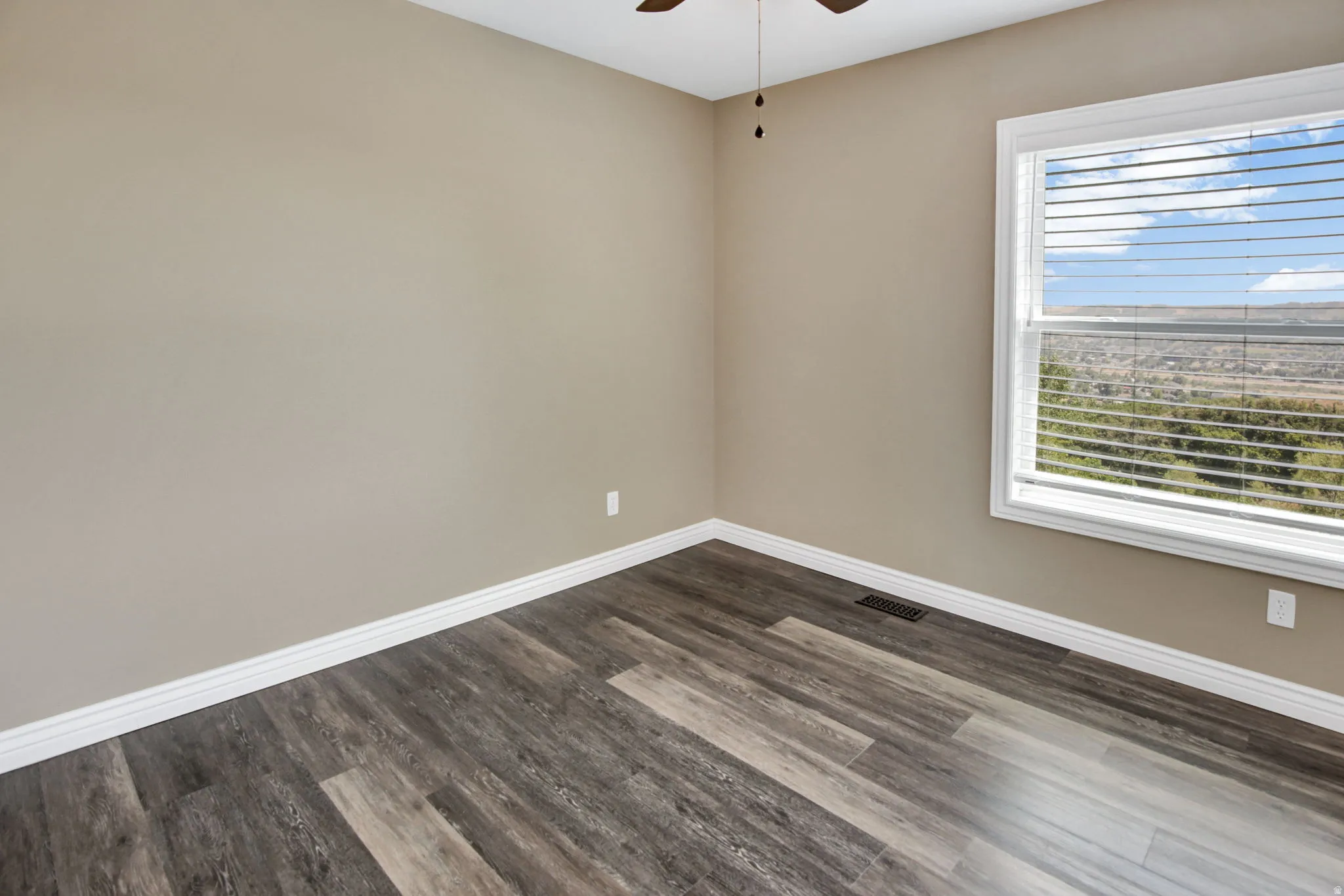 Room featuring wood-finish flooring, neutral wall paint, and white baseboards