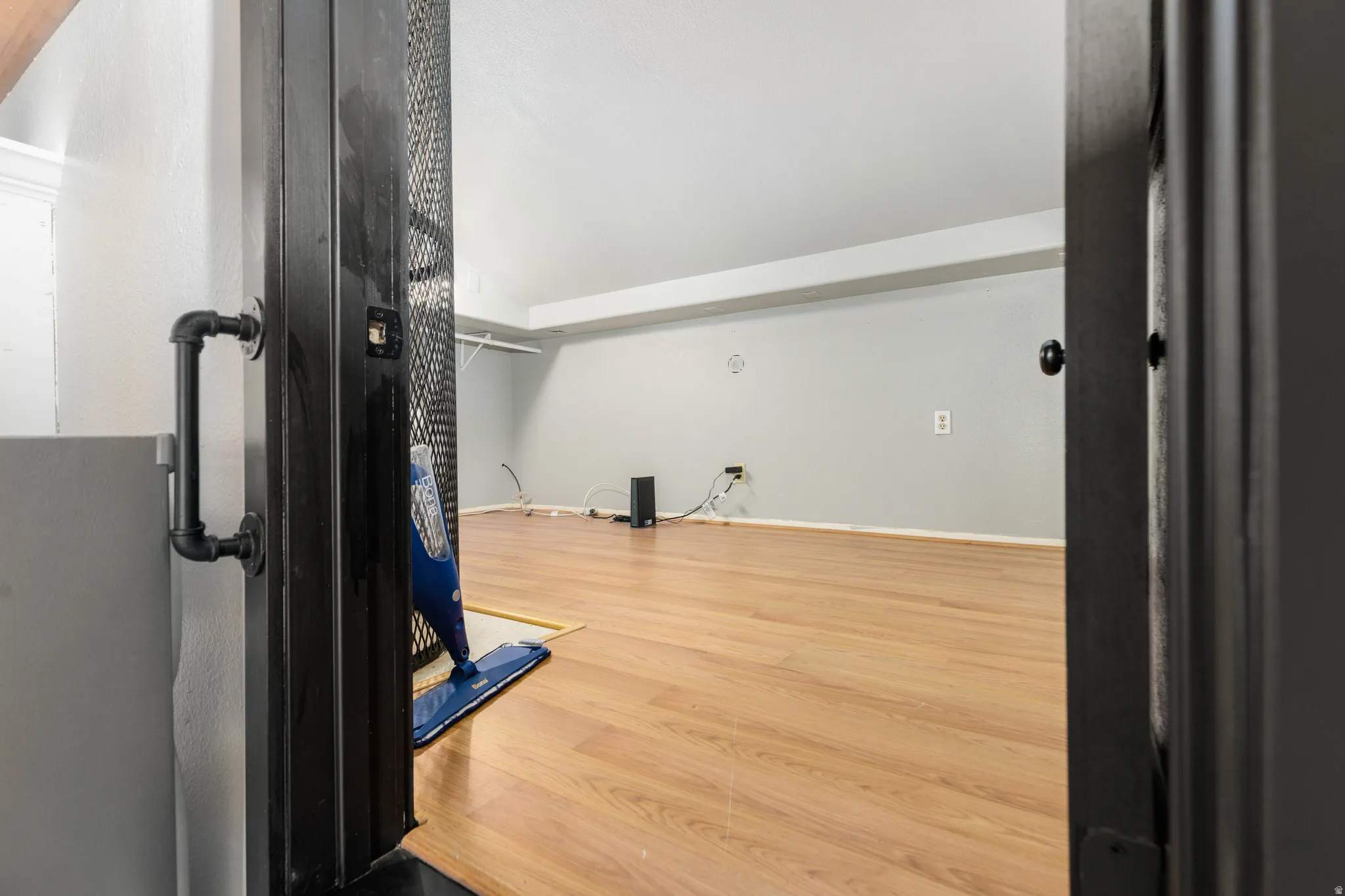 Open room featuring wood-finish flooring and light gray walls