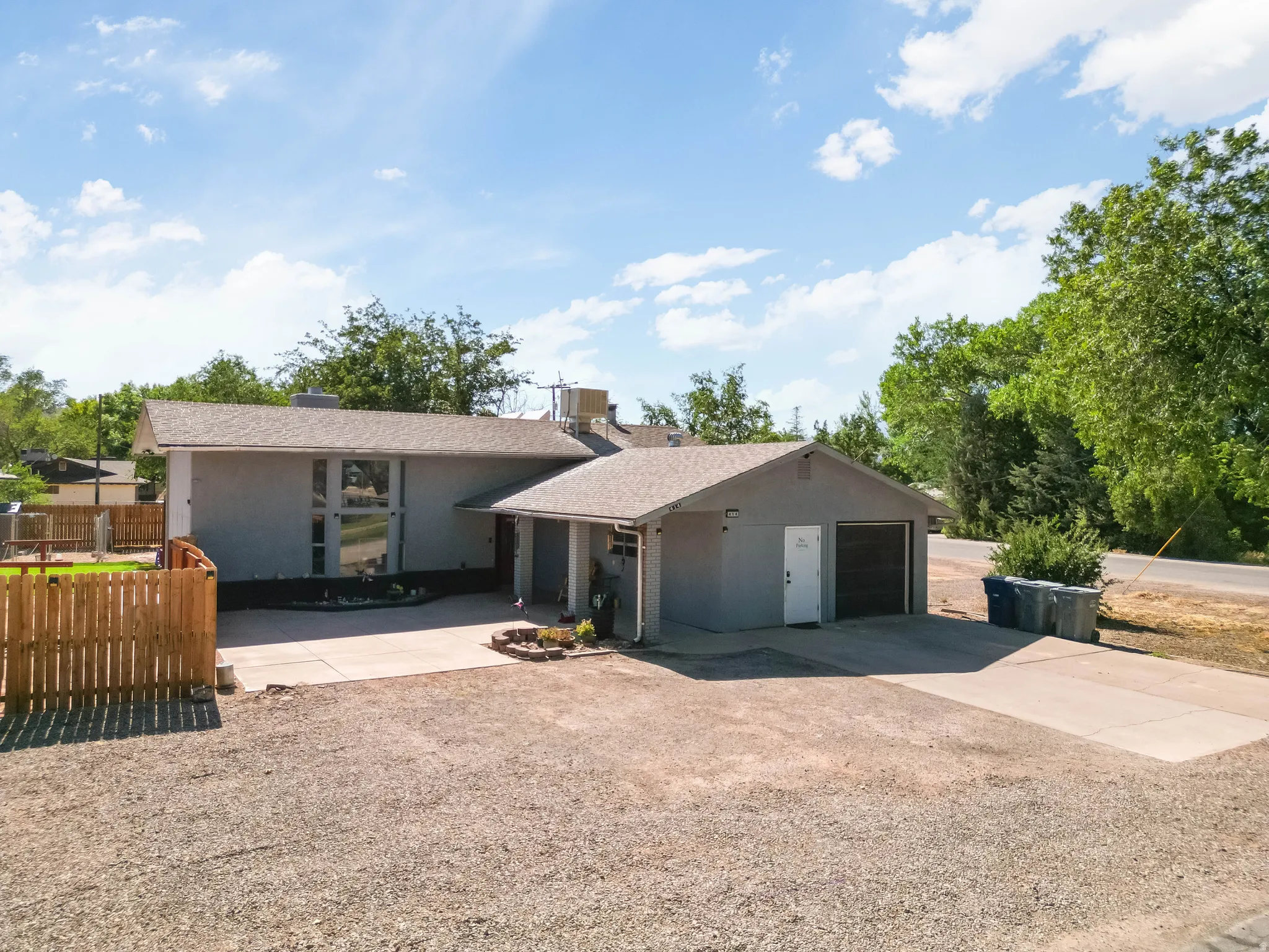 Modern exterior with a light gray stucco finish and a low-slope roof