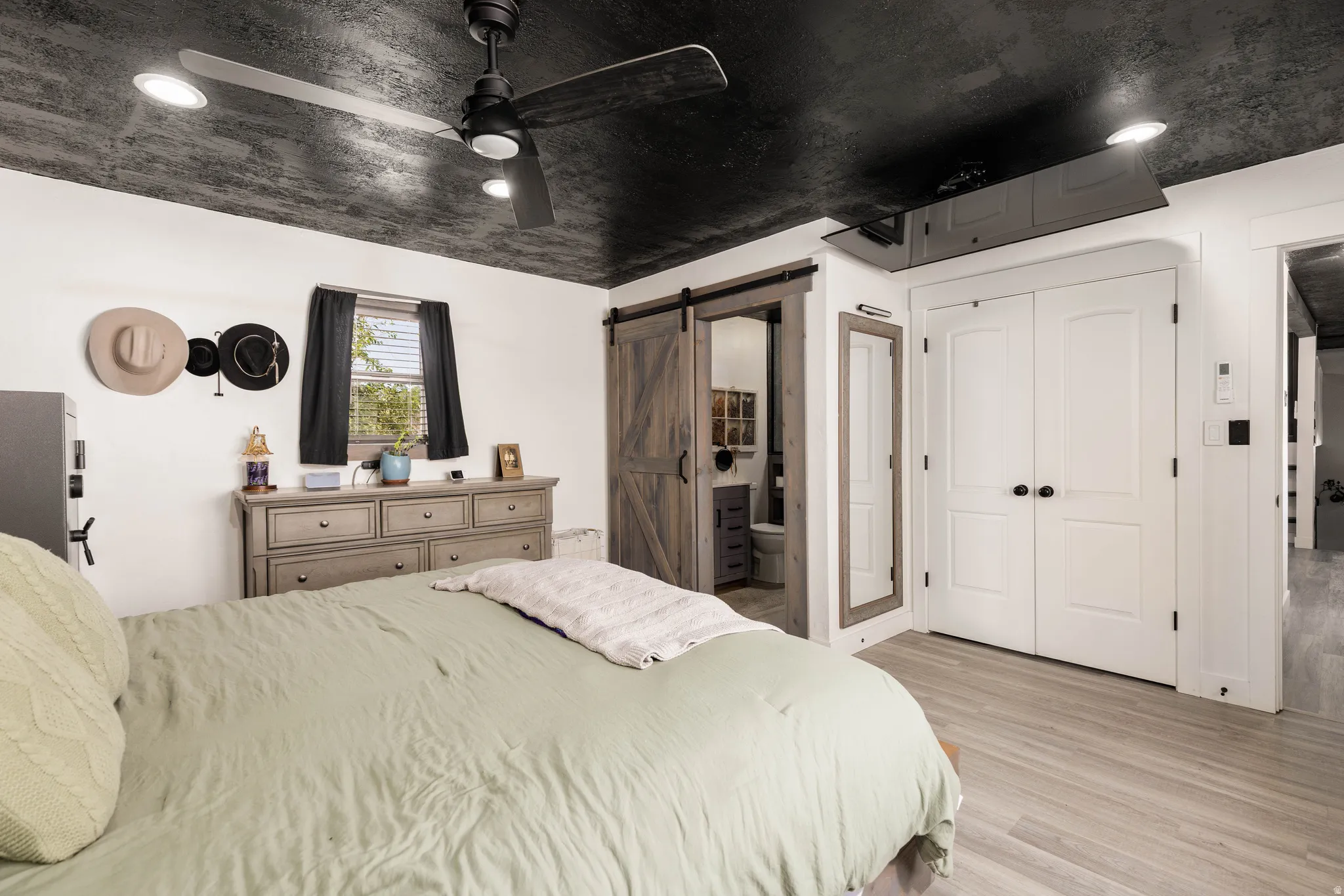 Room featuring a dark textured ceiling with recessed lighting and a ceiling fan